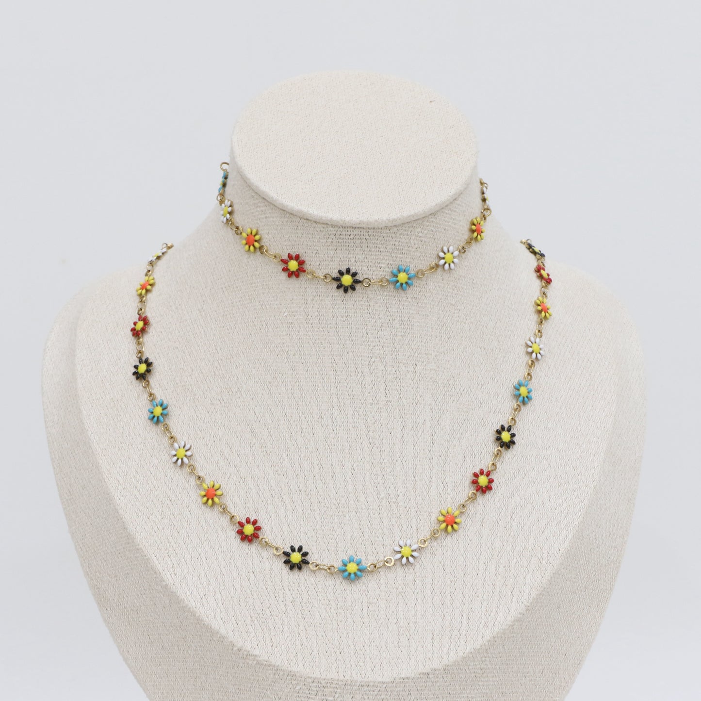 Colorful floral necklace on a mannequin bust against a white background