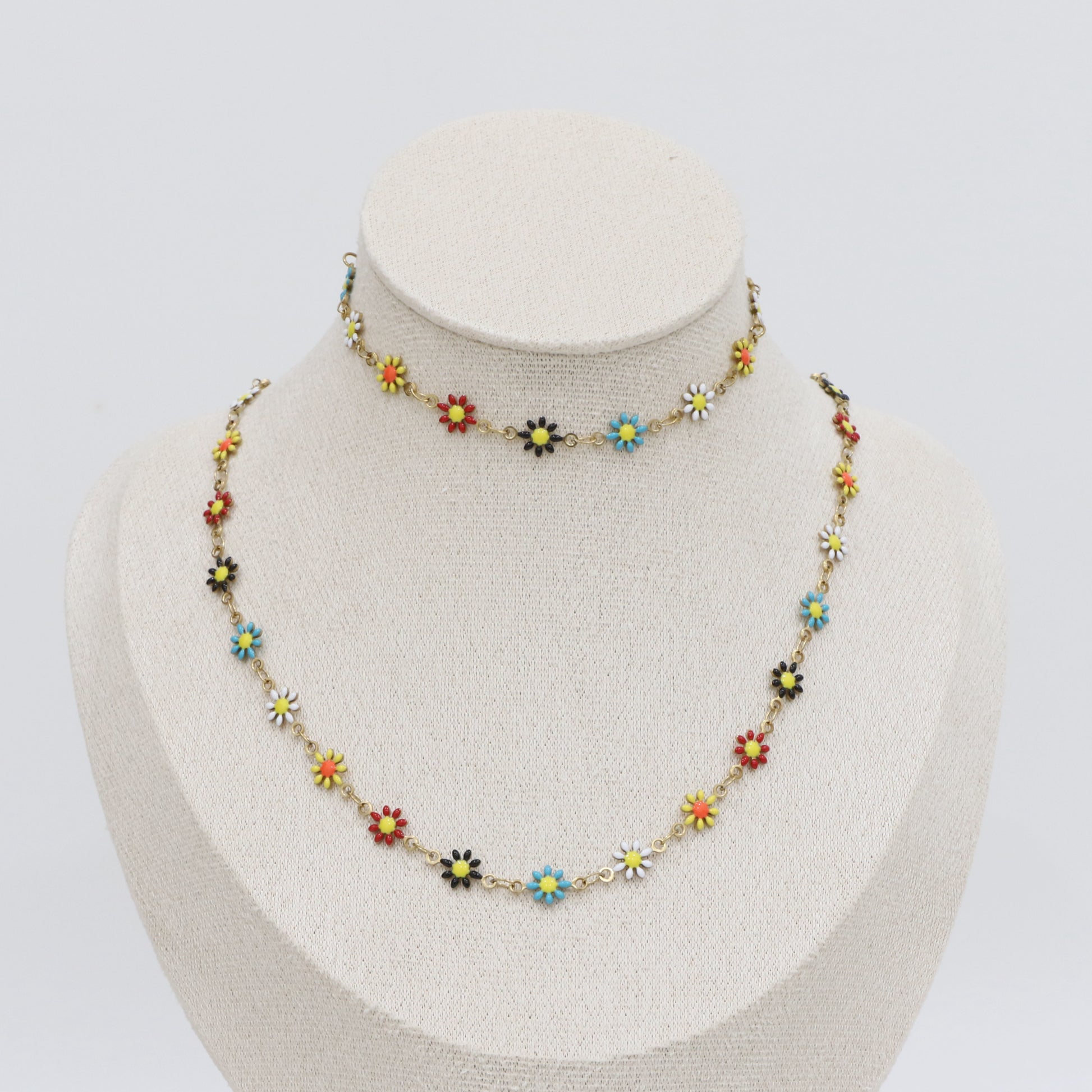 Colorful floral necklace on a mannequin bust against a white background