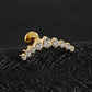 Gold earring with diamonds on a black textured surface