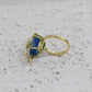 Gold ring with a blue gemstone on a textured gray surface