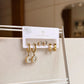 Set of gold and silver earrings on a display card with 'Kalopsia' branding.