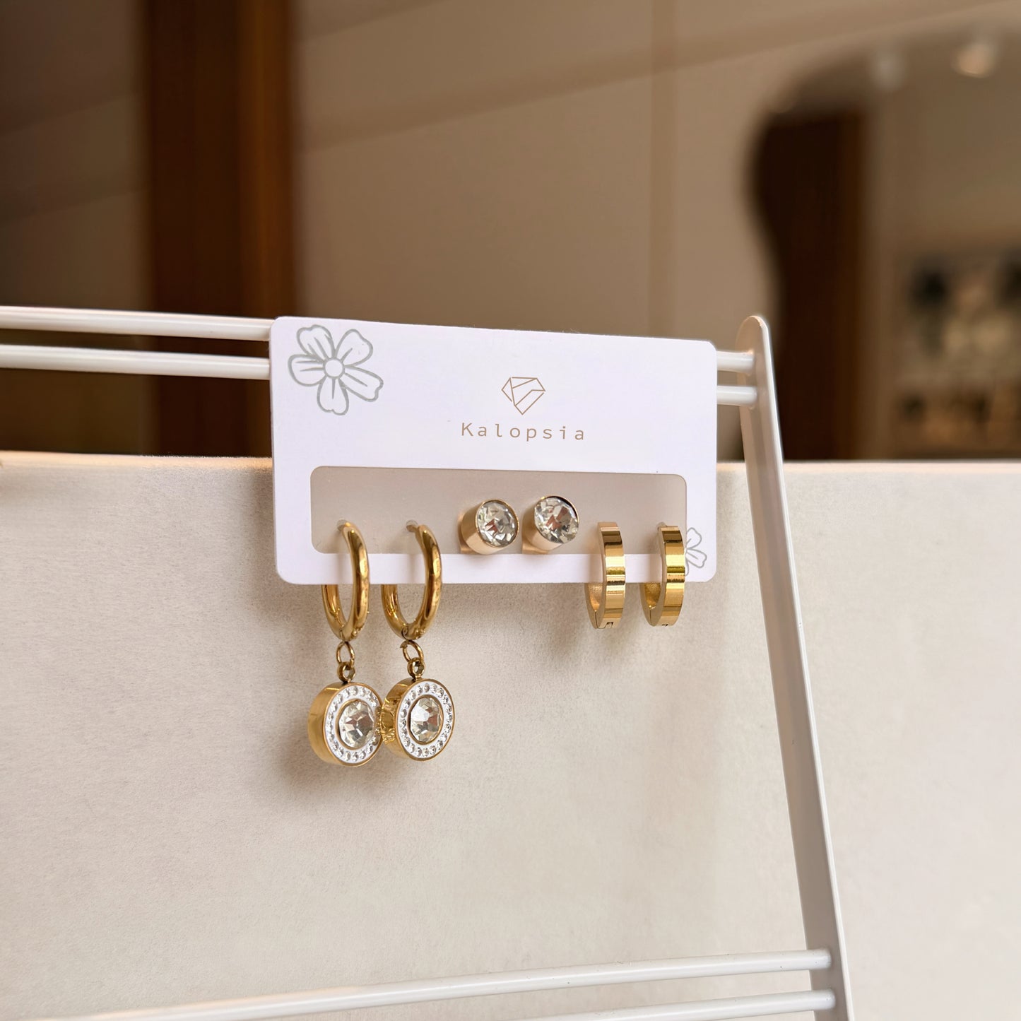 Set of gold and silver earrings on a display card with 'Kalopsia' branding.