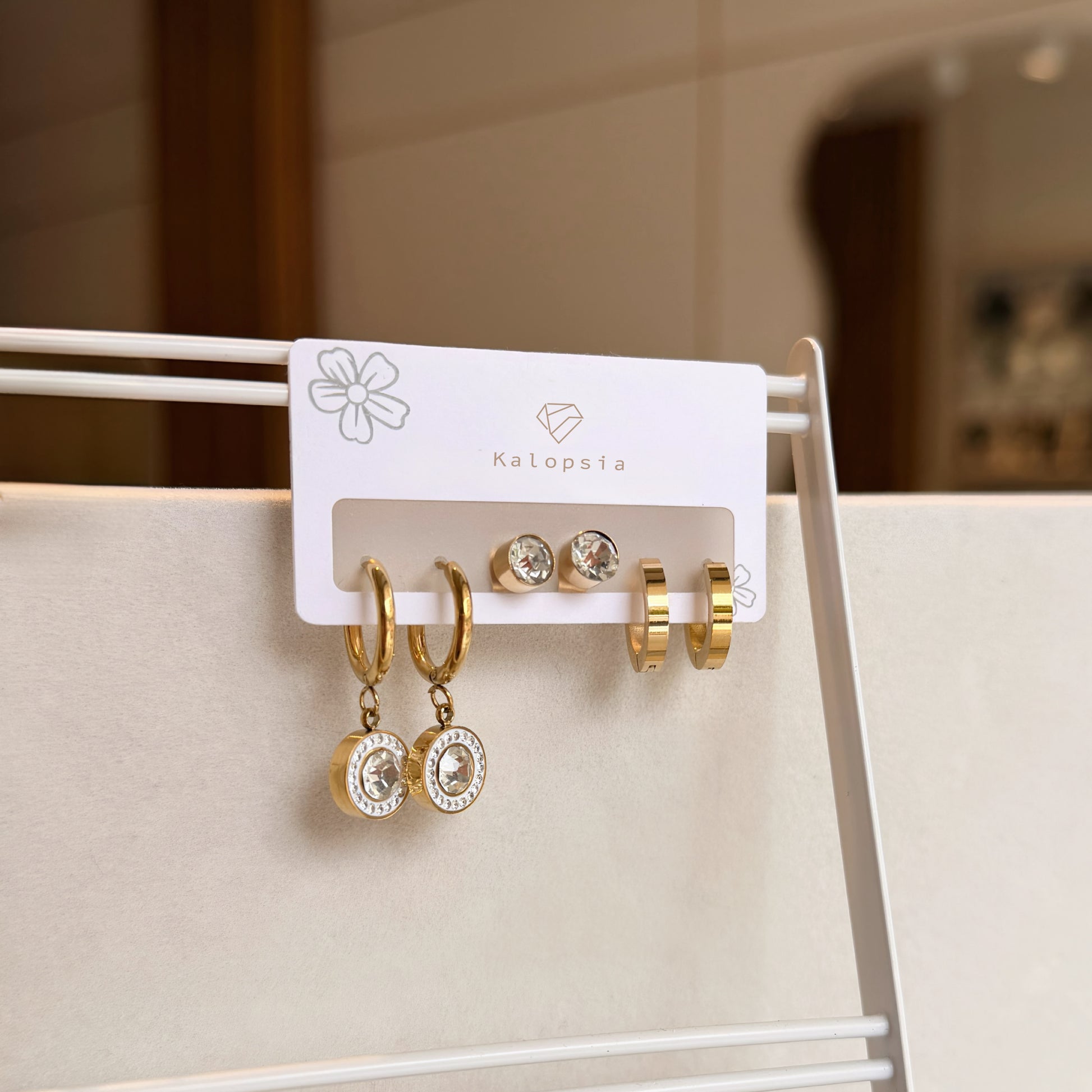 Set of gold and silver earrings on a display card with 'Kalopsia' branding.