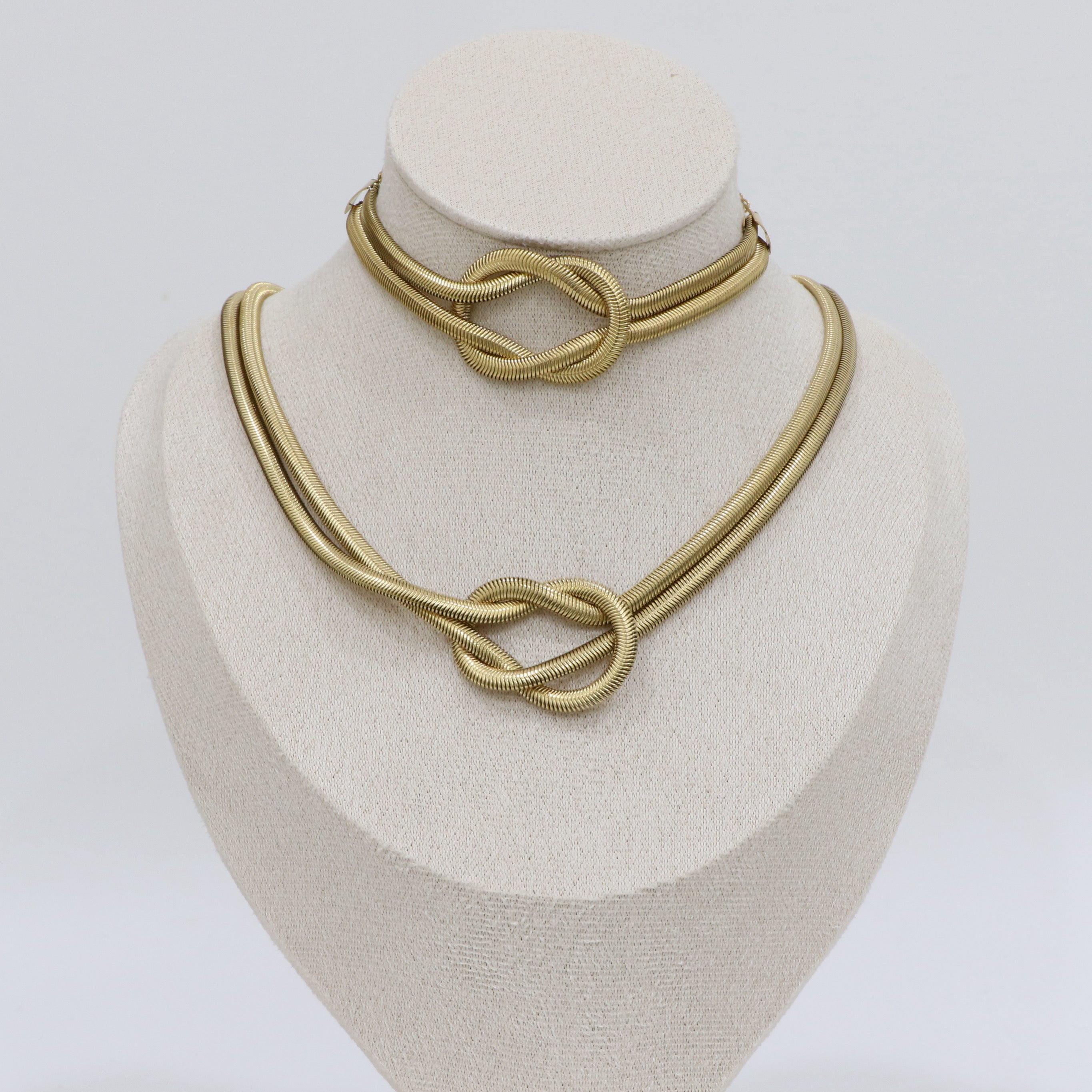 Gold knot necklace on a white mannequin bust