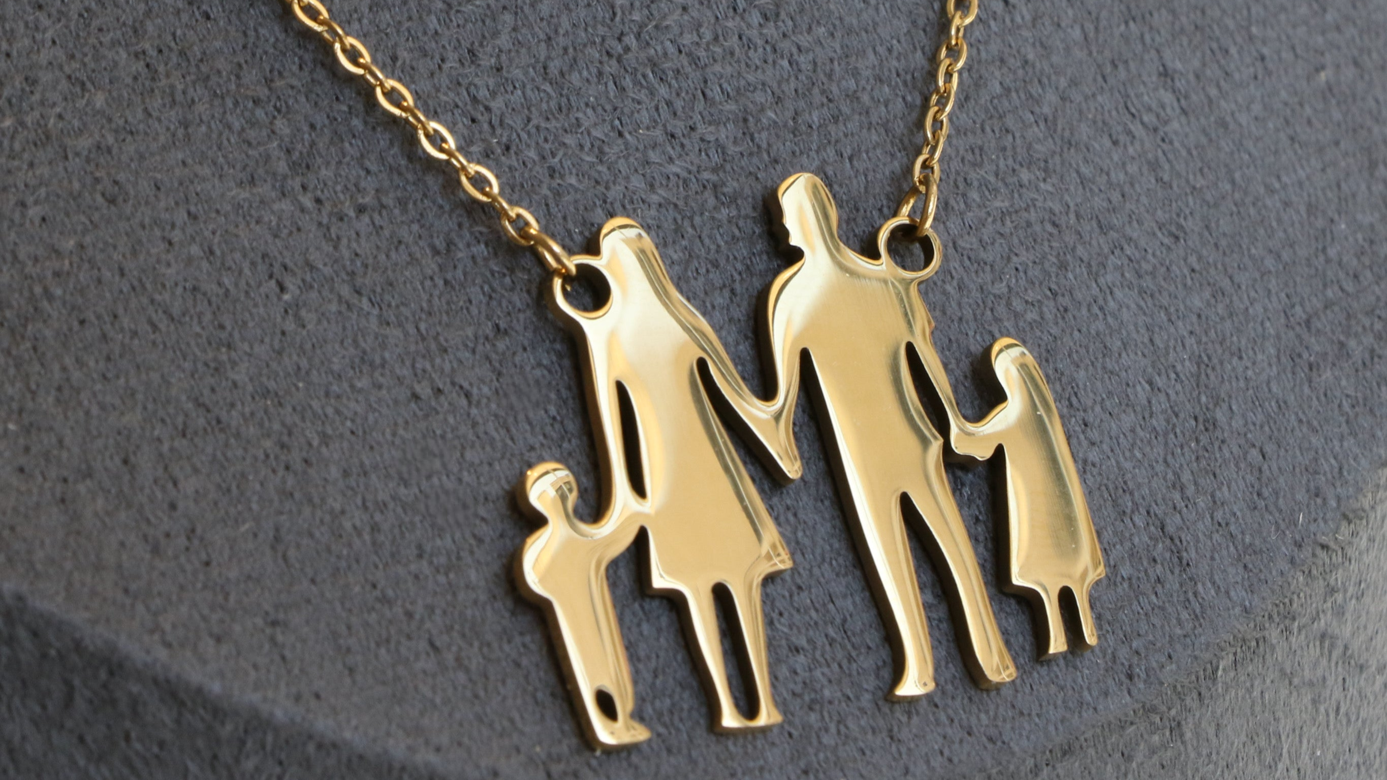 Gold family-themed necklace on a gray background
