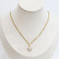 Gold necklace with a star-shaped pendant on a mannequin bust.